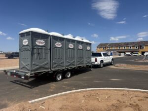 Southwest Sanitation porta potty trailer delivering units to a Phoenix-area home construction site