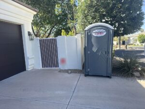 Southwest Sanitation standard porta potty at the front of a home, near the driveway