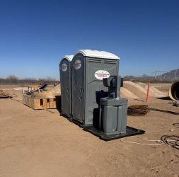 Southwest Sanitation portable hand wash station beside porta potties at a construction site