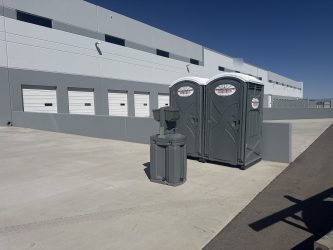 Southwest Sanitation porta potties and a hand wash station outside a warehouse