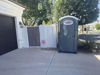 Southwest Sanitation standard porta potty at the front of a home, near the driveway